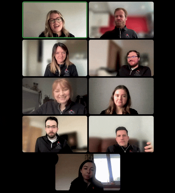 Nine people in a virtual training session grid, each in separate frames, representing PlanitScotland team engaged in discussion, with some smiling.