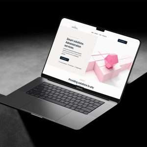 A laptop displaying a website with a headline about smart solutions and administration services sits against a dark background. The screen showcases a pink 3D cube accompanied by smaller cubes. Discover Web Design Inverness to enhance your business with innovative, real cost-effective designs.
