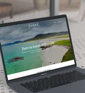 A laptop screen displaying a website with a scenic landscape background. The site's text header reads "Dare to travel differently" with a focus on unique travel experiences in Scotland, crafted by an Inverness-based web design company.